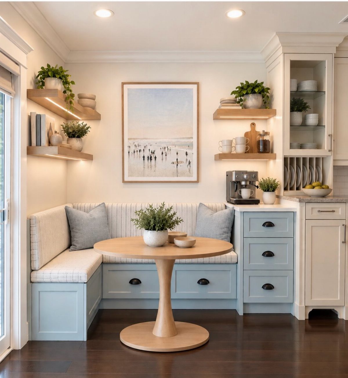 Light blue built-in banquette seating with a round wooden table in a kitchen nook.