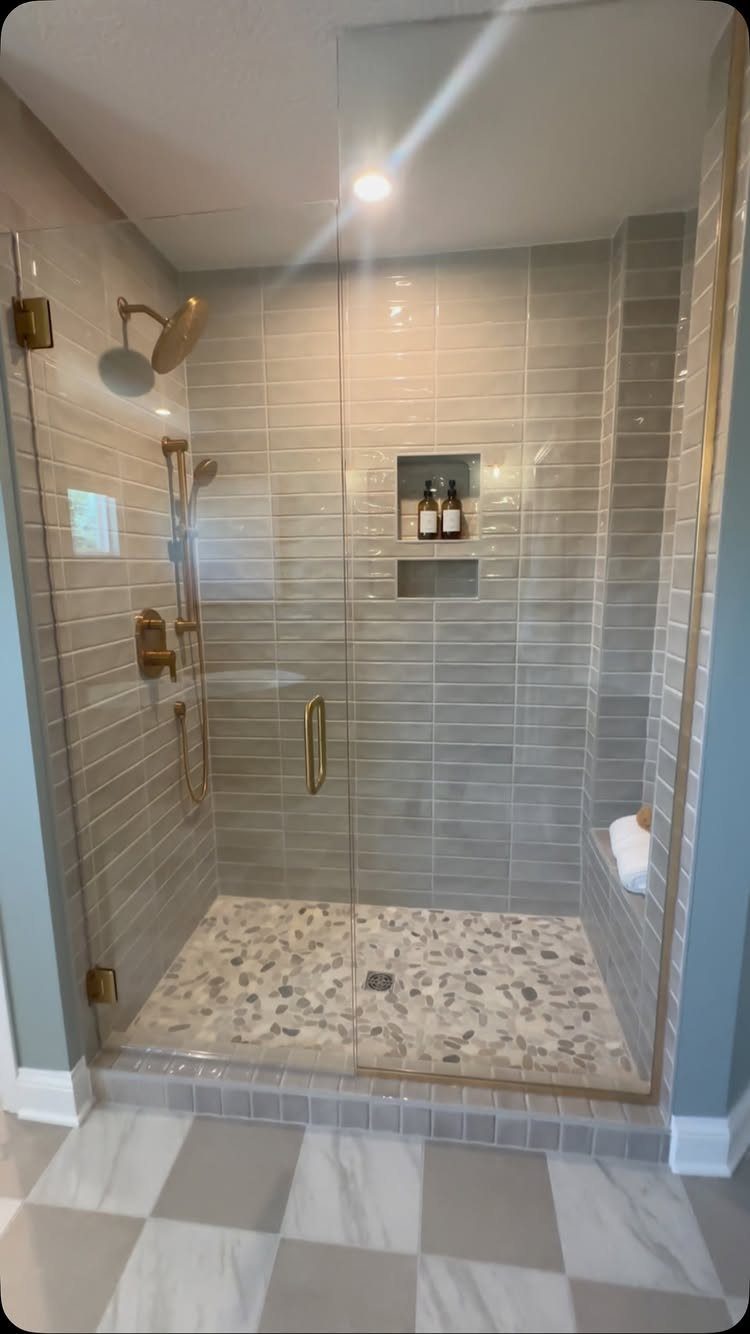 Walk-in shower with grey tiles and a recessed wall niche for storage.