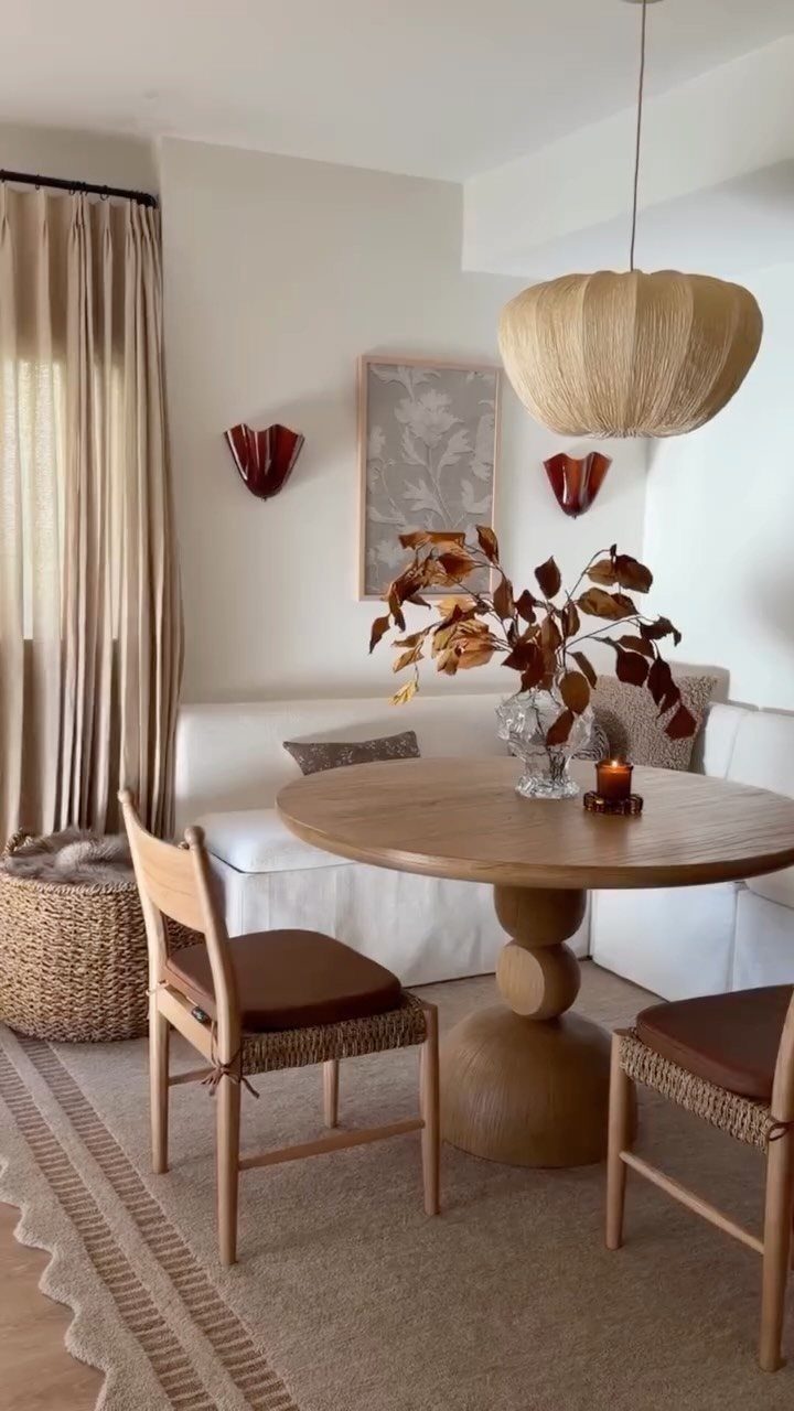 30 Banquette Dining Nook Ideas for Small Kitchens or Corners 25 White wrap-around banquette seating with a round wooden table and neutral decor.