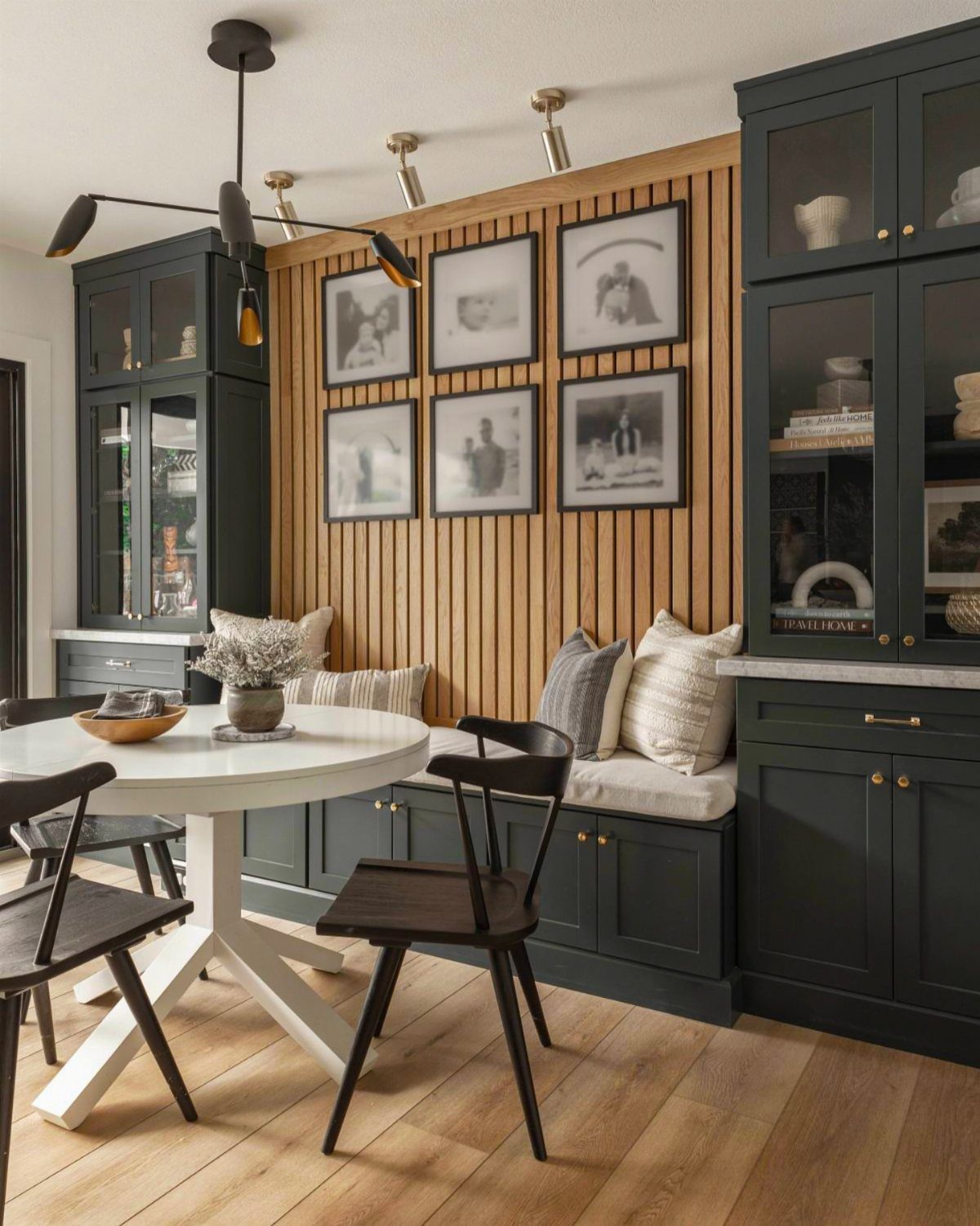 30 Banquette Dining Nook Ideas for Small Kitchens or Corners 4 Dark green built-in banquette with white cushions and a round white dining table.