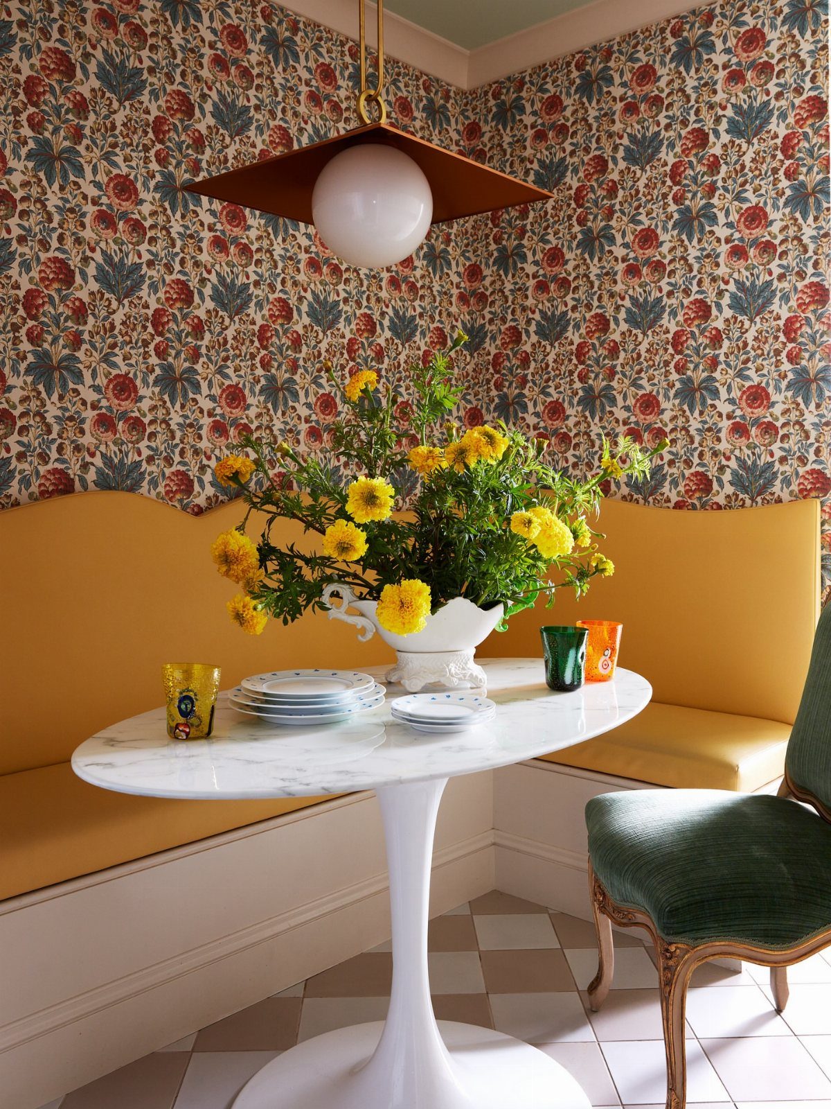 30 Banquette Dining Nook Ideas for Small Kitchens or Corners 23 Yellow velvet banquette and marble table against red and blue floral botanical wallpaper