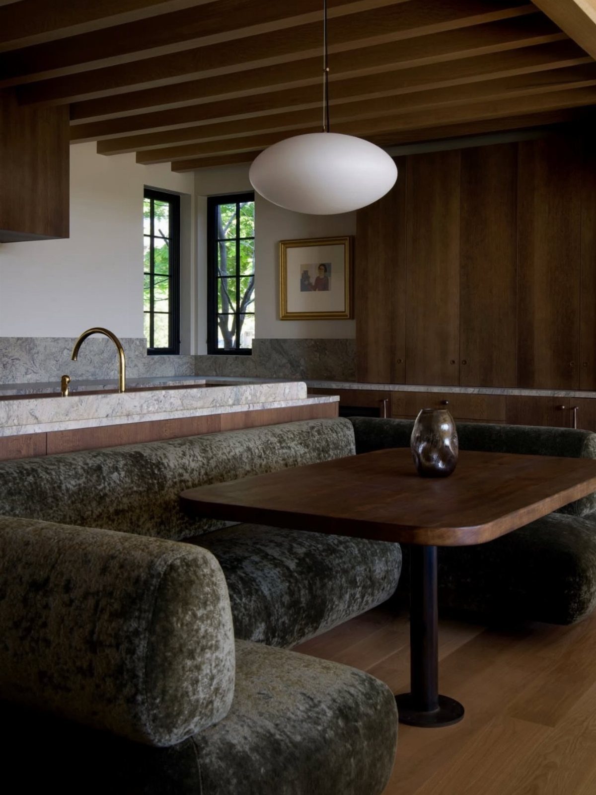 30 Banquette Dining Nook Ideas for Small Kitchens or Corners 7 Dark curved velvet banquette and dark wood table under wooden ceiling beams.
