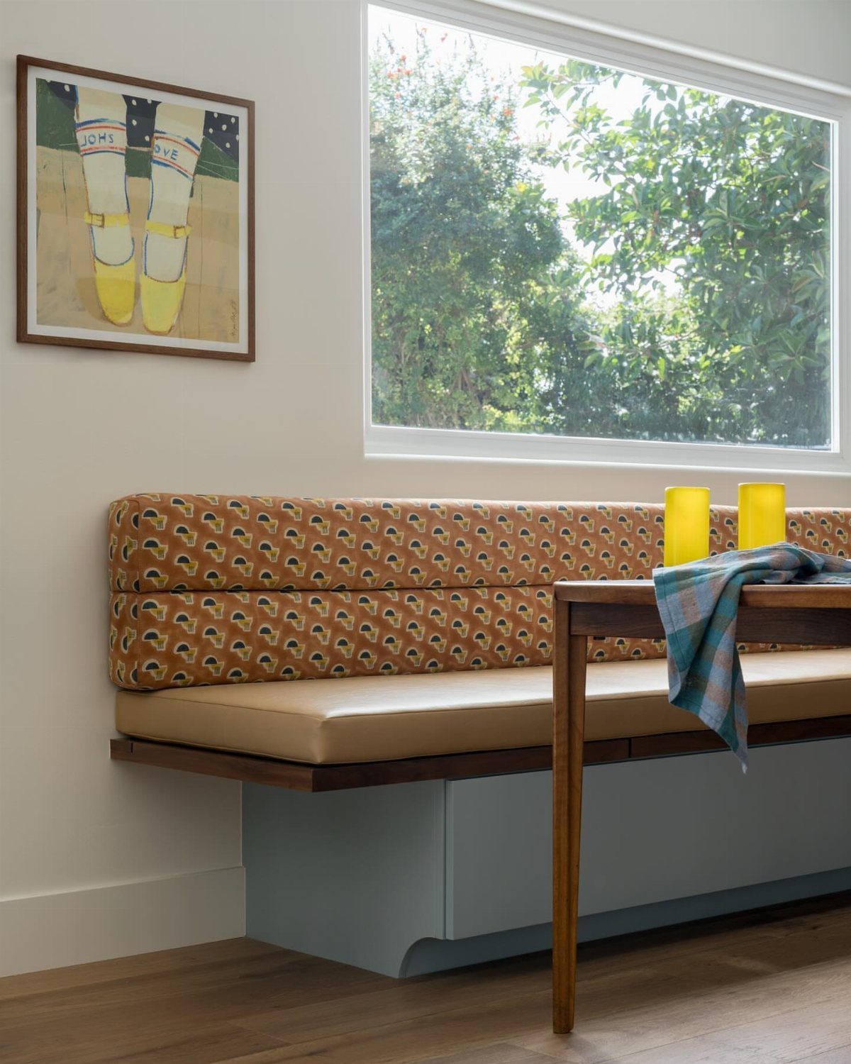 30 Banquette Dining Nook Ideas for Small Kitchens or Corners 24 Built-in dining nook with patterned orange backrest and light blue base by a window.
