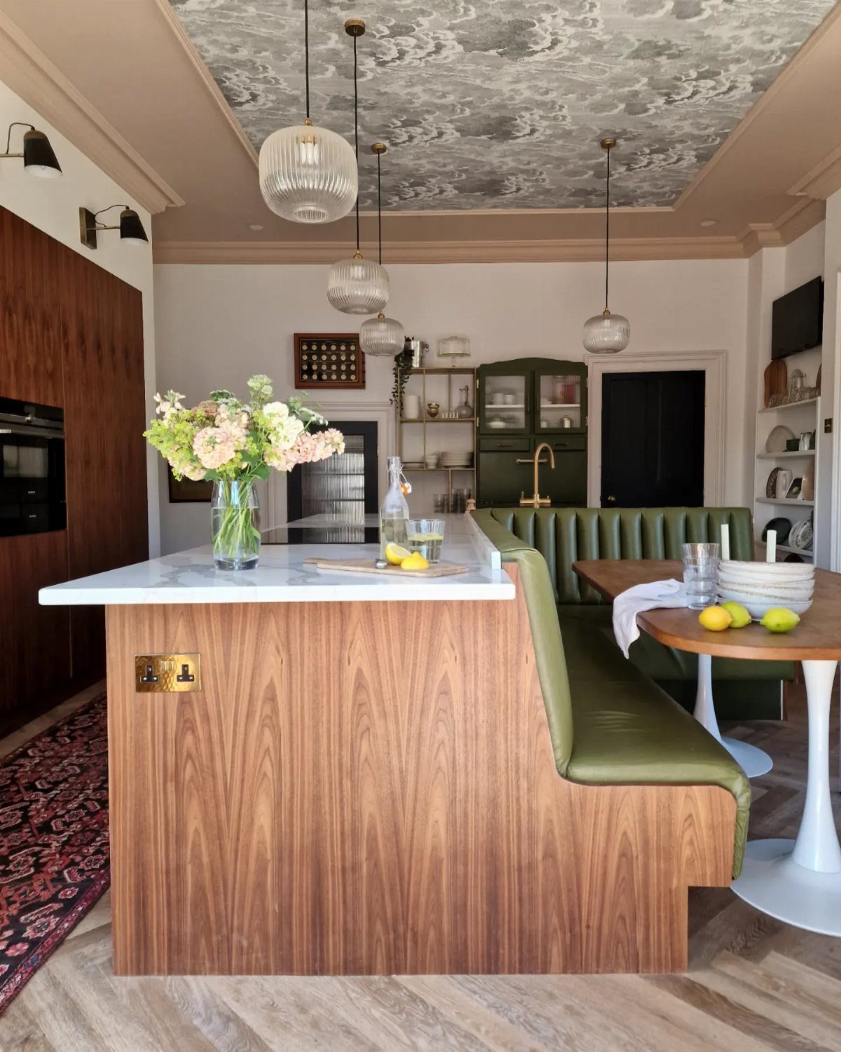 30 Banquette Dining Nook Ideas for Small Kitchens or Corners 11 Green leather L-shaped banquette attached to a wooden kitchen island with marble top.