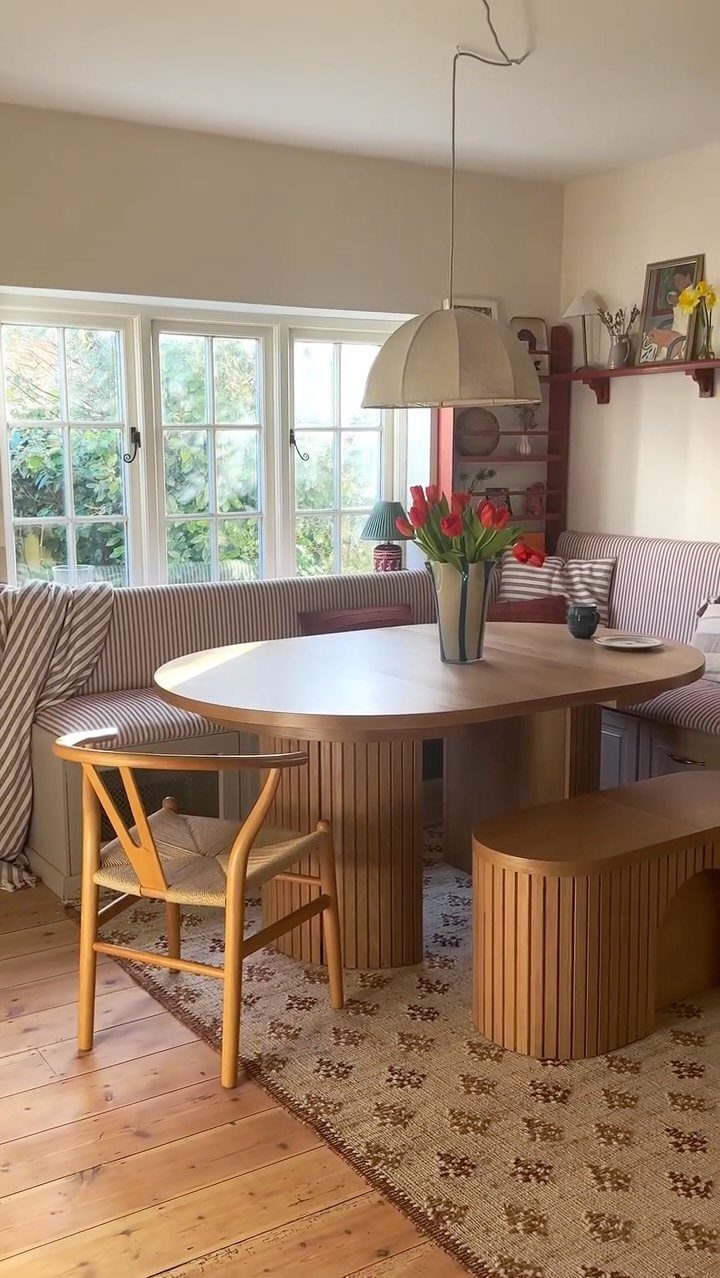 30 Banquette Dining Nook Ideas for Small Kitchens or Corners 6 L-shaped striped banquette dining nook positioned in front of a bright window.