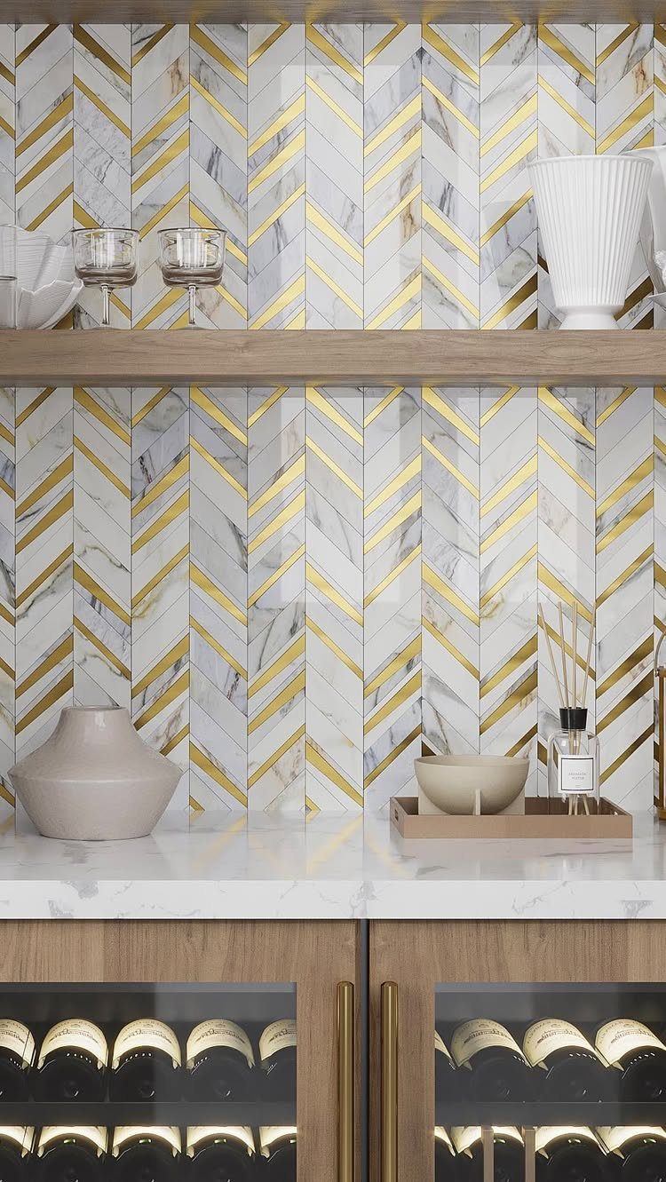 Home bar with white and gold chevron marble backsplash and wine storage cabinets.