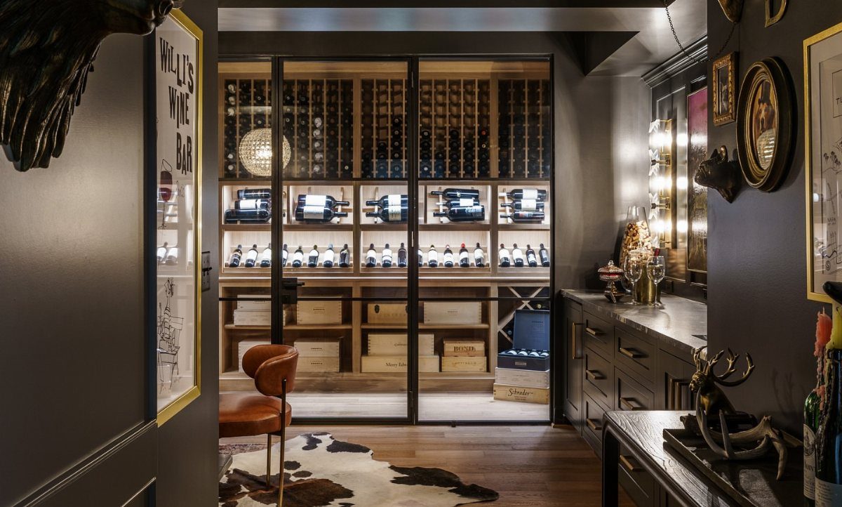 Glass-enclosed wine cellar with wooden racks and bottles in a dark modern room
