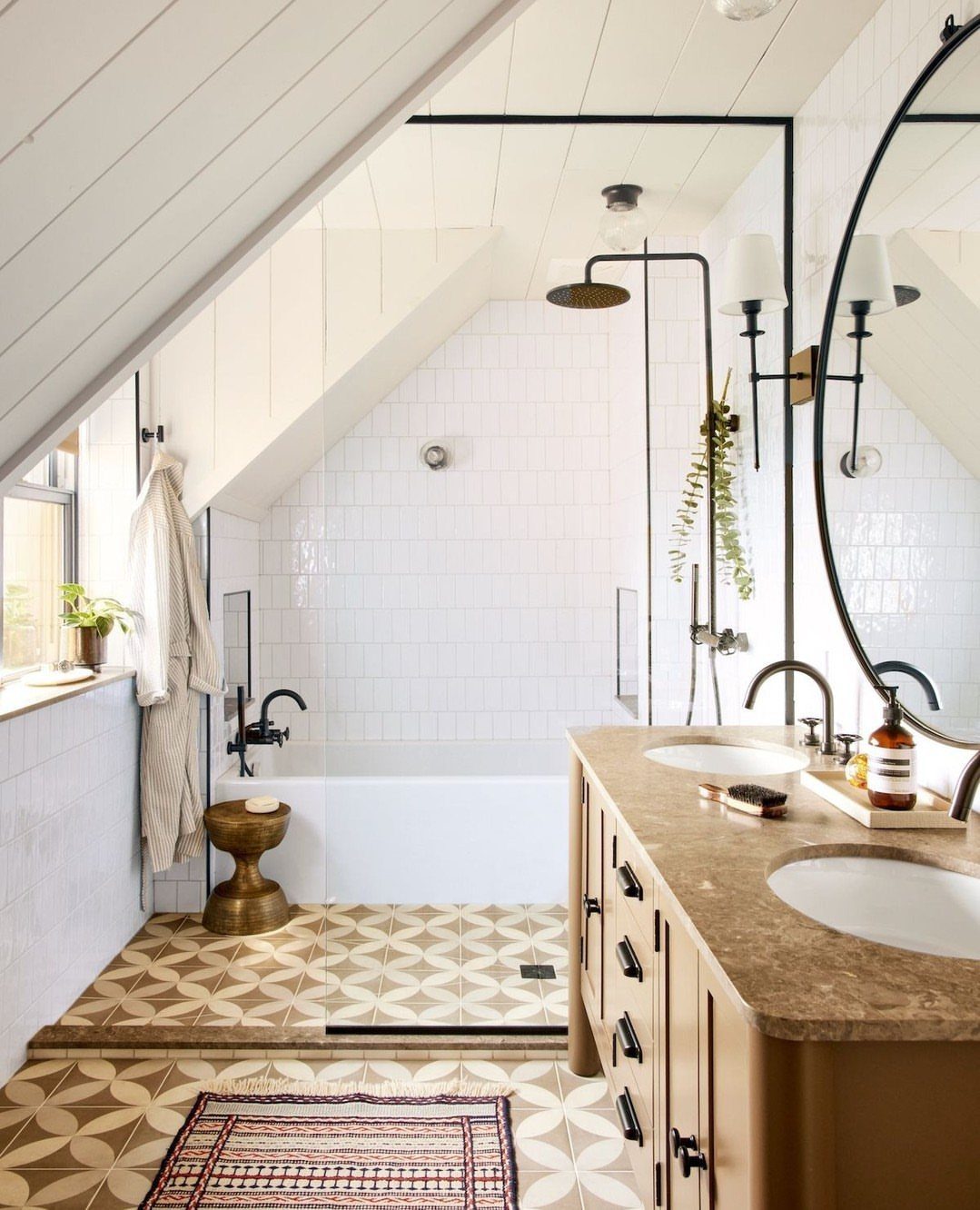 White bathtub installed under a sloped ceiling in a bright, modern bathroom.