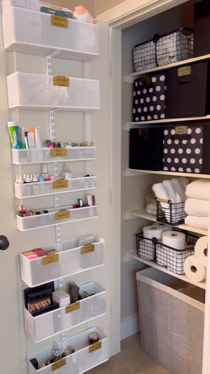 White hanging door organizer with mesh bins containing toiletries and makeup in a bathroom.