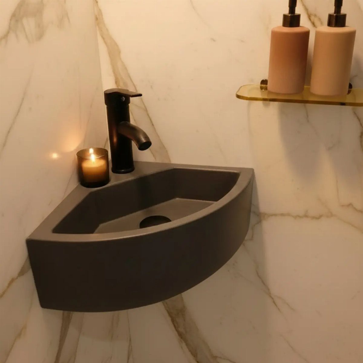Grey triangular corner sink with black faucet on a white marble wall.