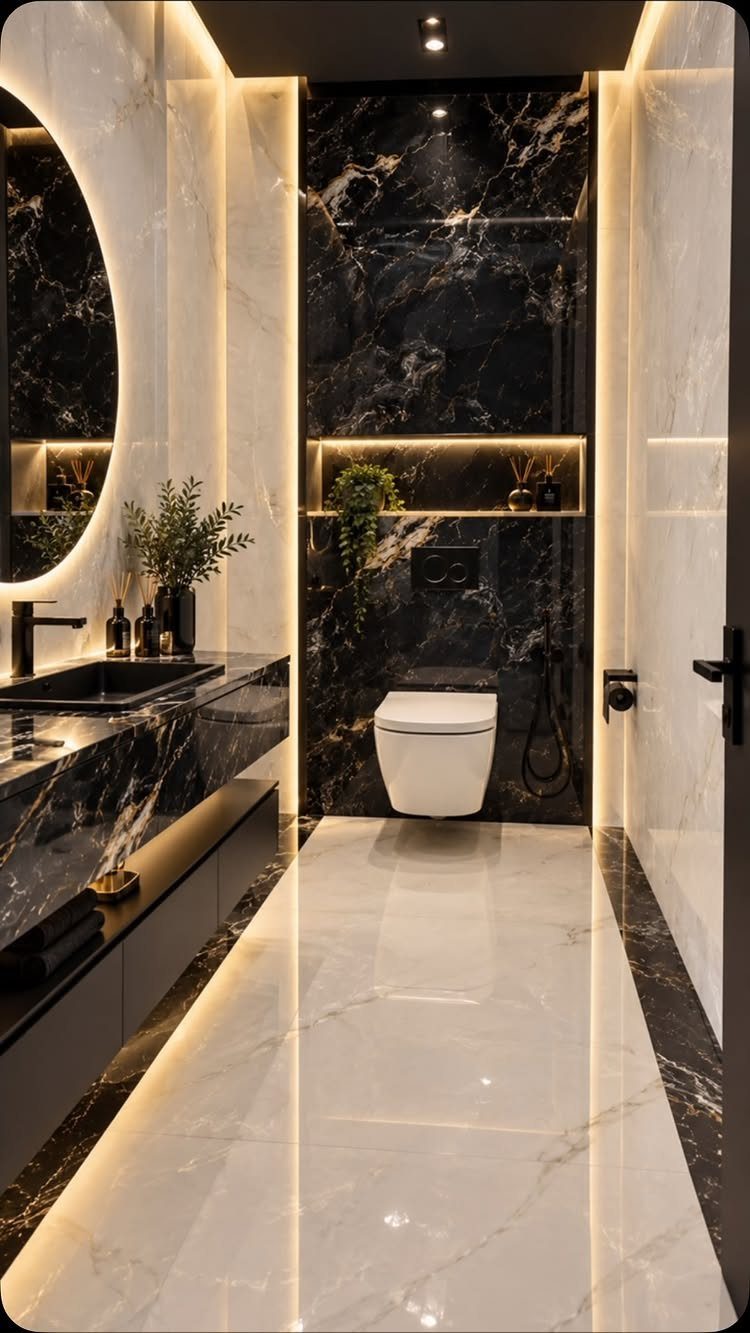 Modern narrow bathroom with large black and white marble tiles and LED lighting.