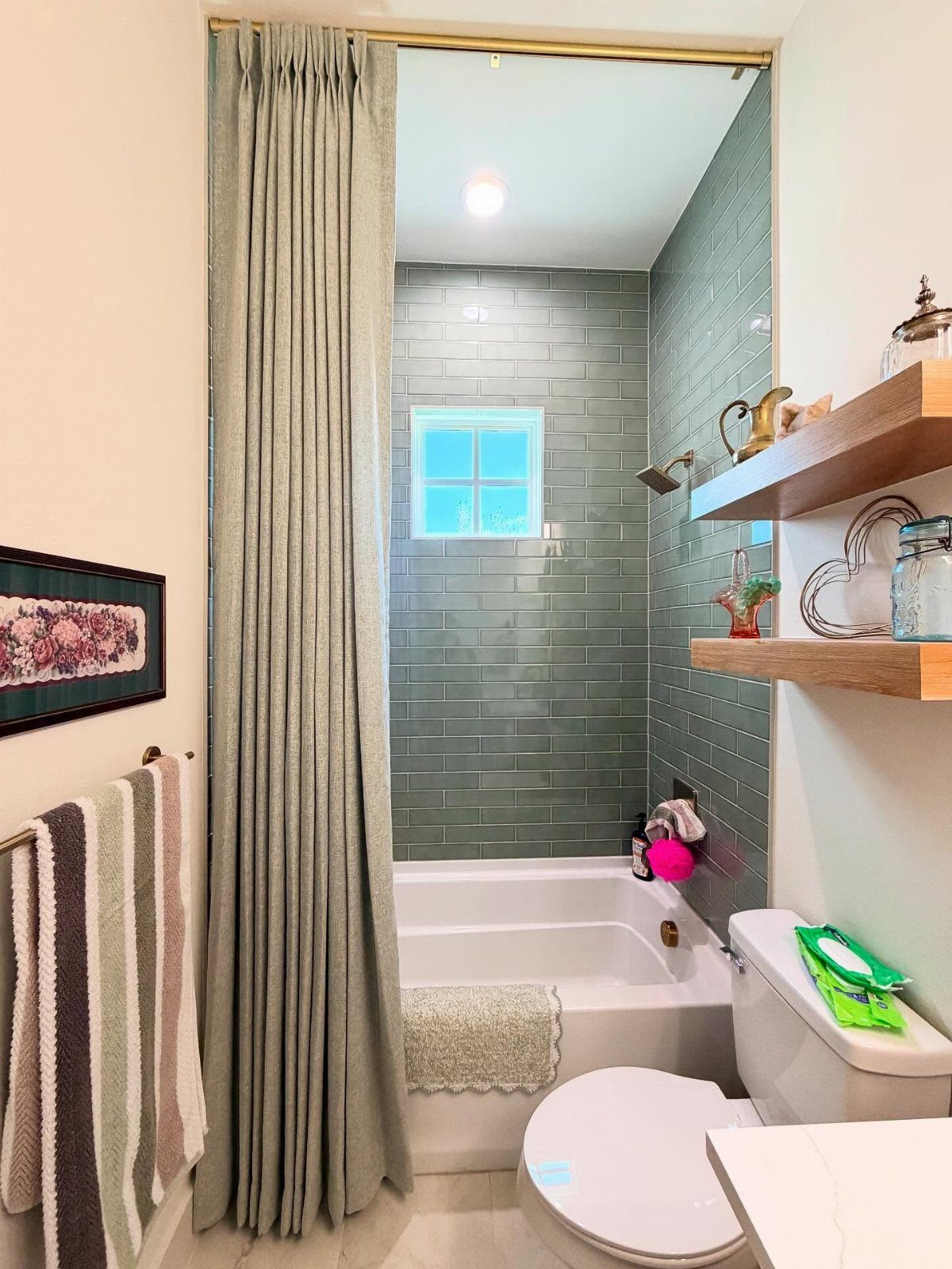 Grey fabric shower curtain hanging over a white bathtub in a small bathroom.