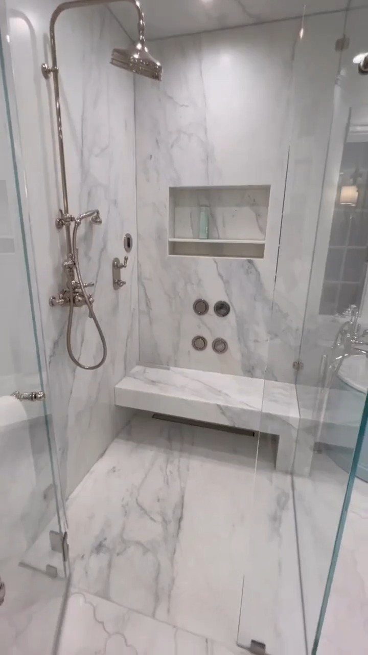 Marble walk-in shower with rain shower head, body jets, and a built-in bench.