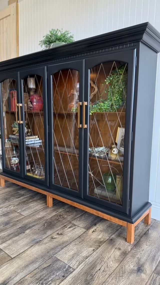 12 Dining Room Decor Hutch Ideas, From Farmhouse to Japandi 12 Black wooden hutch with glass doors and gold hardware on a wood floor.