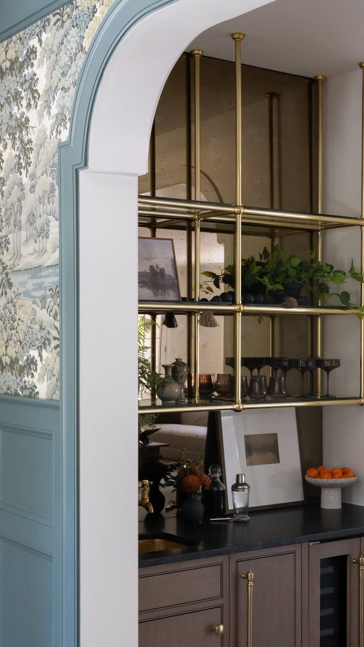 12 Dining Room Decor Hutch Ideas, From Farmhouse to Japandi 3 Gold metal shelving with glassware and mirrored back in a sophisticated home bar.