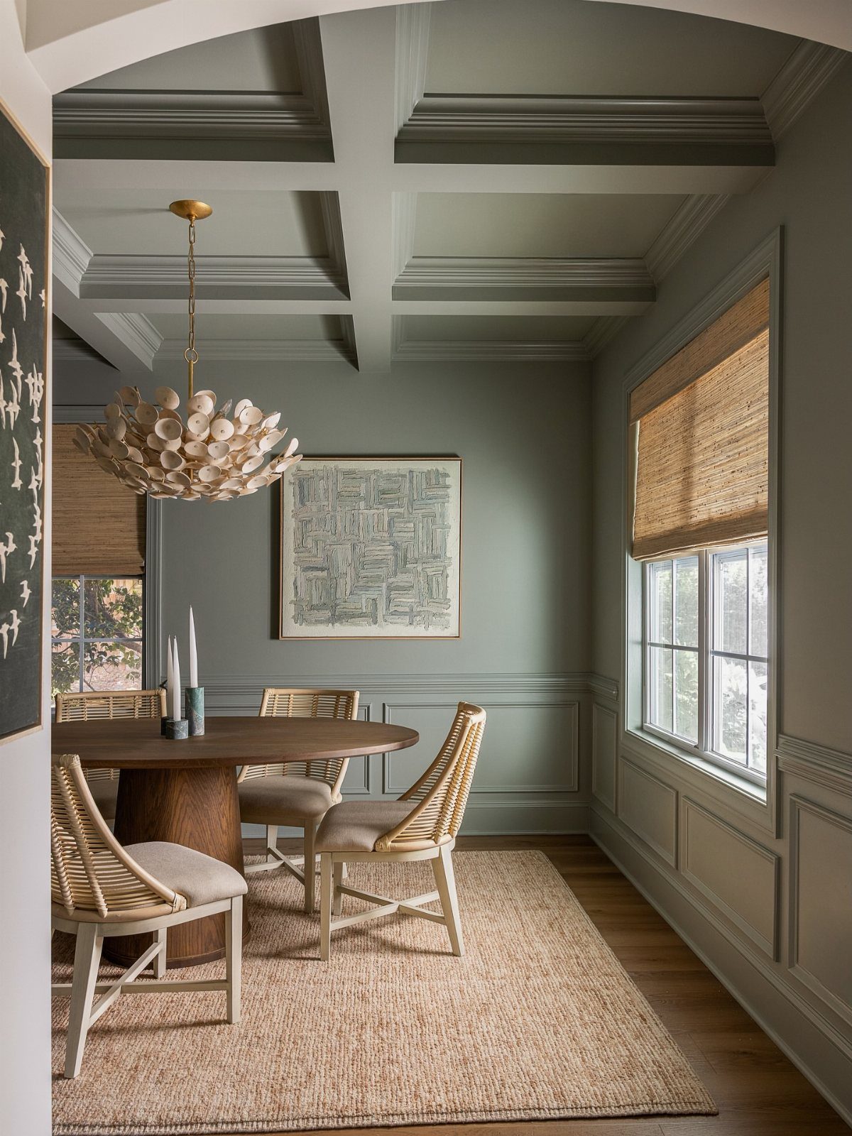 Dining room with sage green walls, ceiling, and trim, featuring a round wooden table.