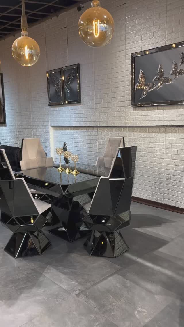 Modern dining set with faceted black mirrored chairs and a matching reflective table.