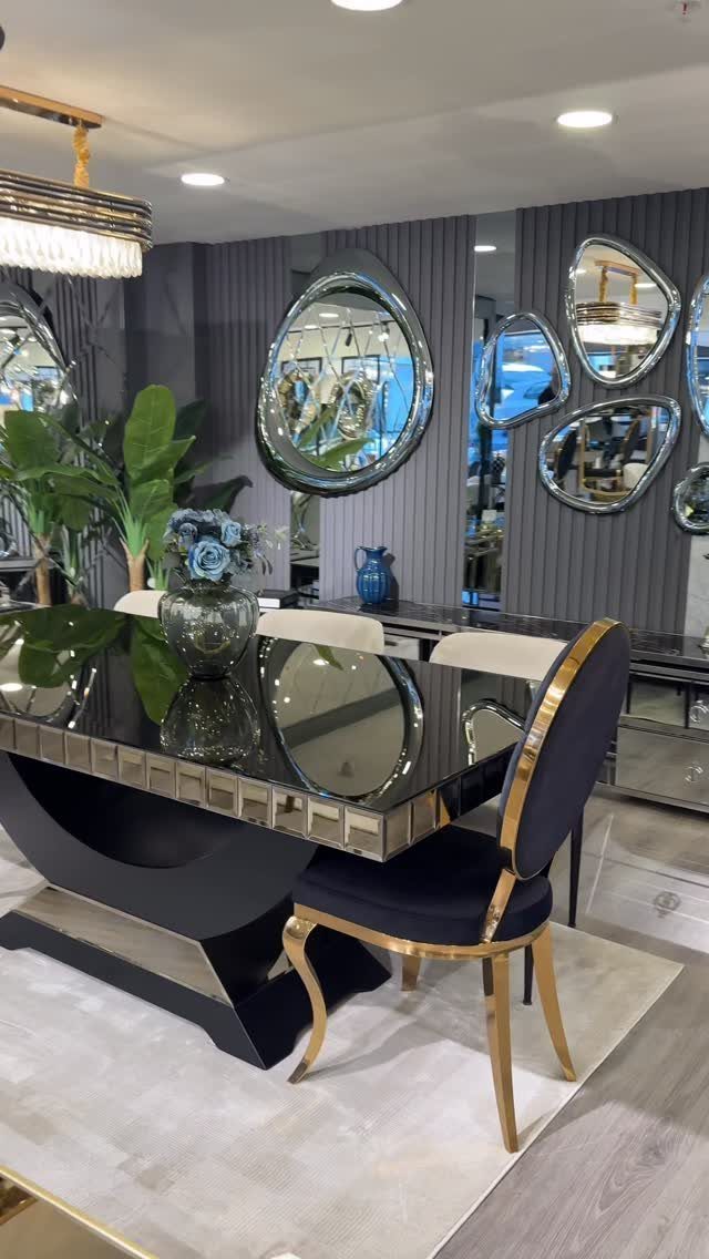 Modern dining room with organic shaped mirrors on a grey paneled wall