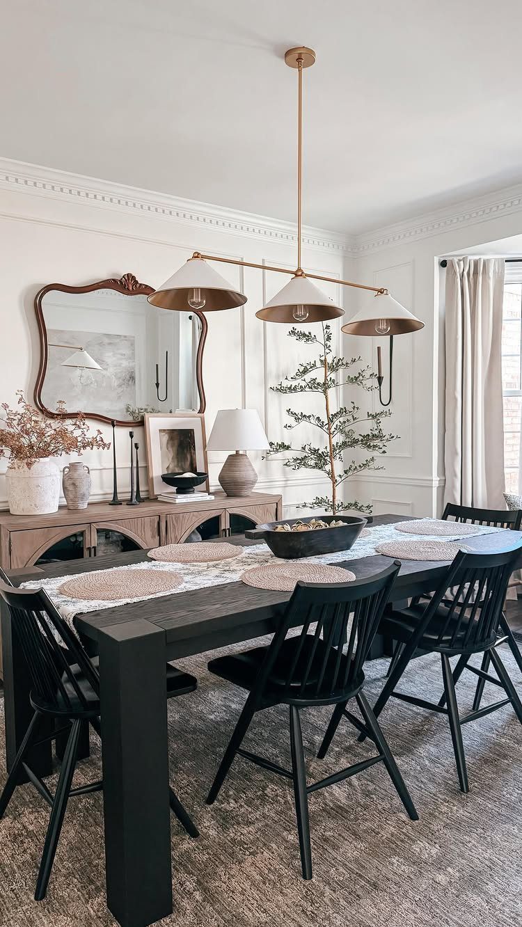 Ornate vintage mirror hanging above a wooden sideboard in a modern dining room.