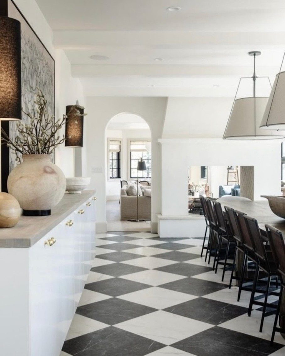 Black and white checkered diamond floor in a bright modern kitchen and dining area.