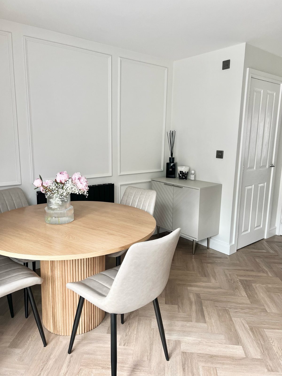 Dining Room Side Cabinet Designs with 18 Stylish Options 17 White minimalist dining cabinet next to a round wooden table and grey chairs.