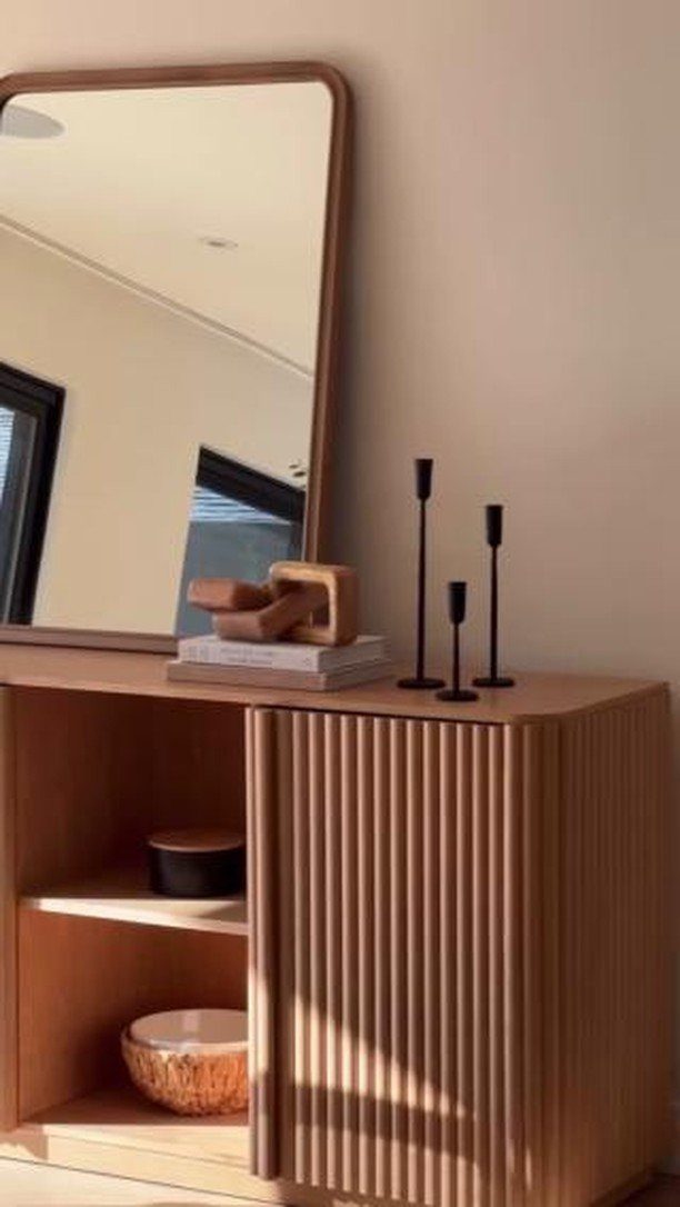Dining Room Side Cabinet Designs with 18 Stylish Options 1 Light wood fluted sideboard with a matching wall mirror and black candle holders.