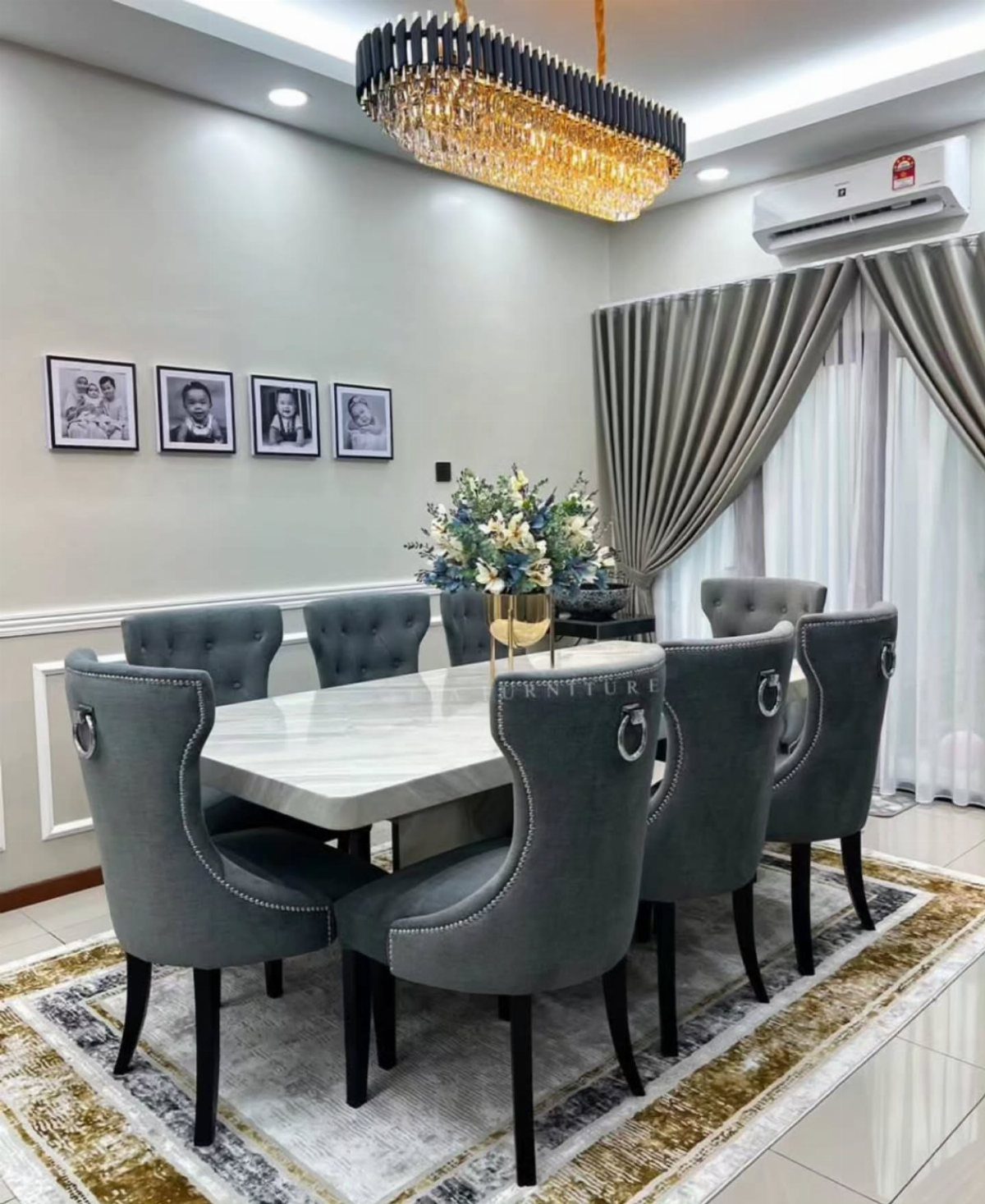 Large white marble dining table with eight grey upholstered chairs in a modern room.
