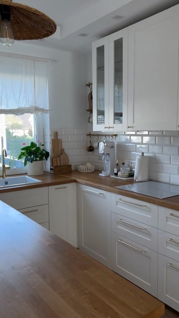 Wooden butcher block countertops in a white kitchen with subway tile backsplash