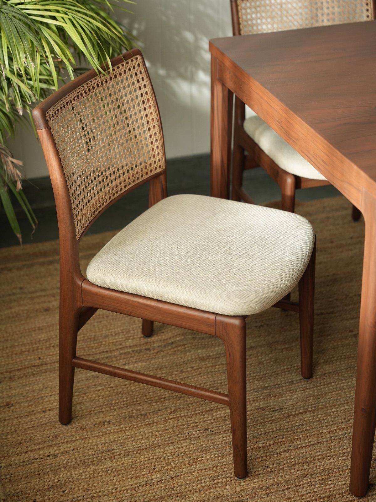 Fabric Chairs Dining Ideas: 32 Styles, Colors, and Frames 14 Wooden dining chair with woven cane back and white fabric seat by a table.