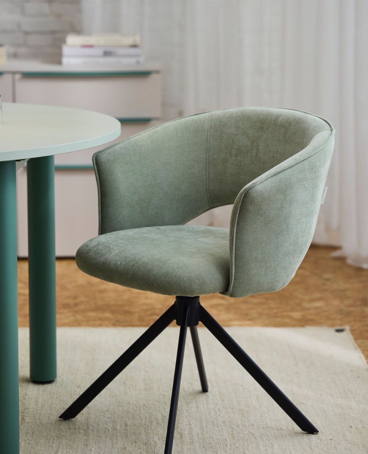 Fabric Chairs Dining Ideas: 32 Styles, Colors, and Frames 6 Light green upholstered swivel chair with curved back and black metal legs by teal table.