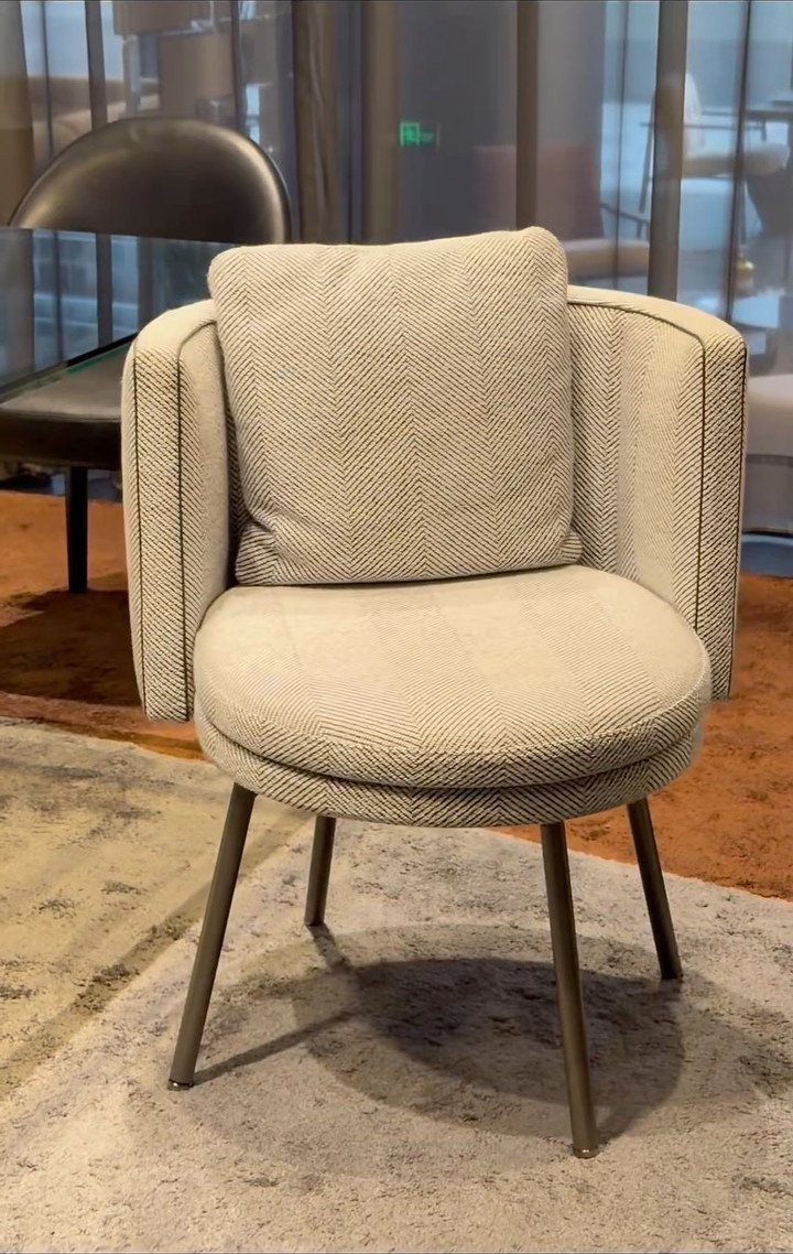 Fabric Chairs Dining Ideas: 32 Styles, Colors, and Frames 2 Beige upholstered barrel-back armchair with a cushion and dark metal legs on a rug.