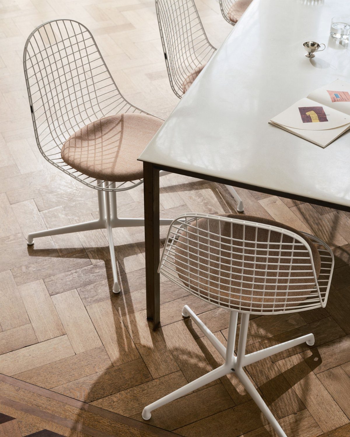 Fabric Chairs Dining Ideas: 32 Styles, Colors, and Frames 16 White wire-frame dining chairs with tan cushions around a white table on wood flooring.