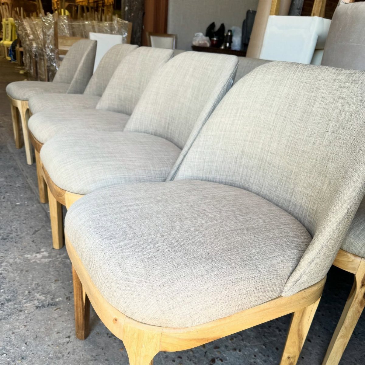 Fabric Chairs Dining Ideas: 32 Styles, Colors, and Frames 24 Light gray fabric dining chairs with light wood frames arranged in a row.