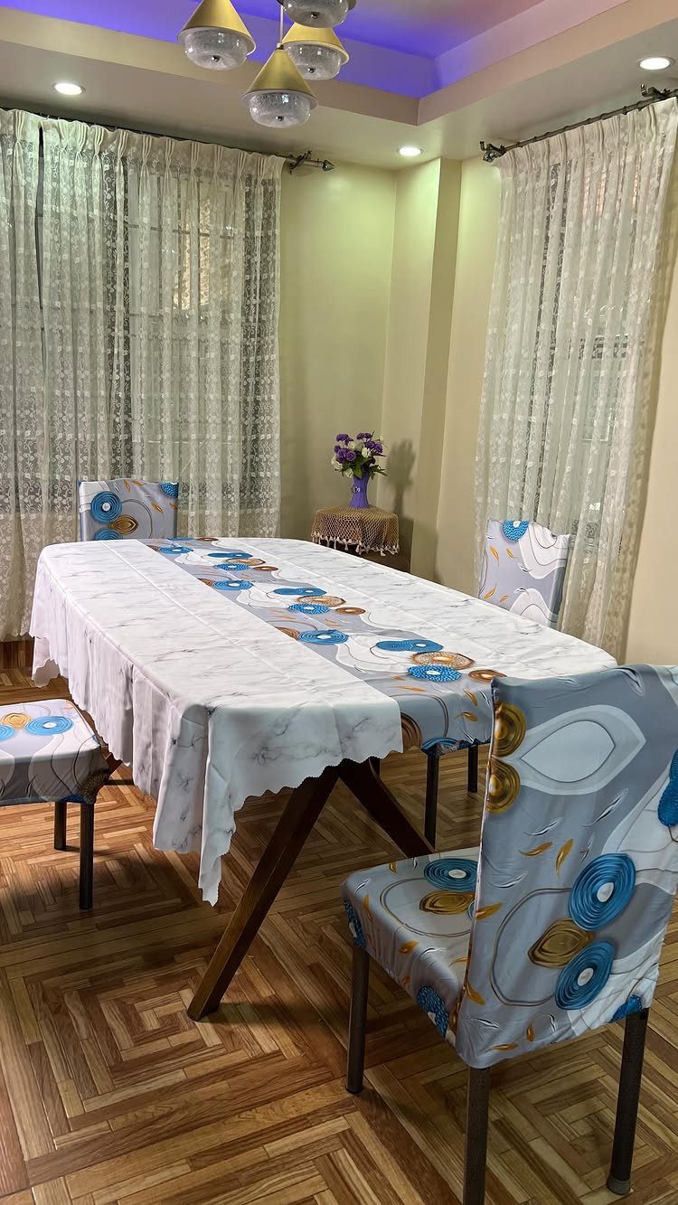 Fabric Chairs Dining Ideas: 32 Styles, Colors, and Frames 23 Dining table with chairs covered in blue and gold patterned fabric slipcovers.