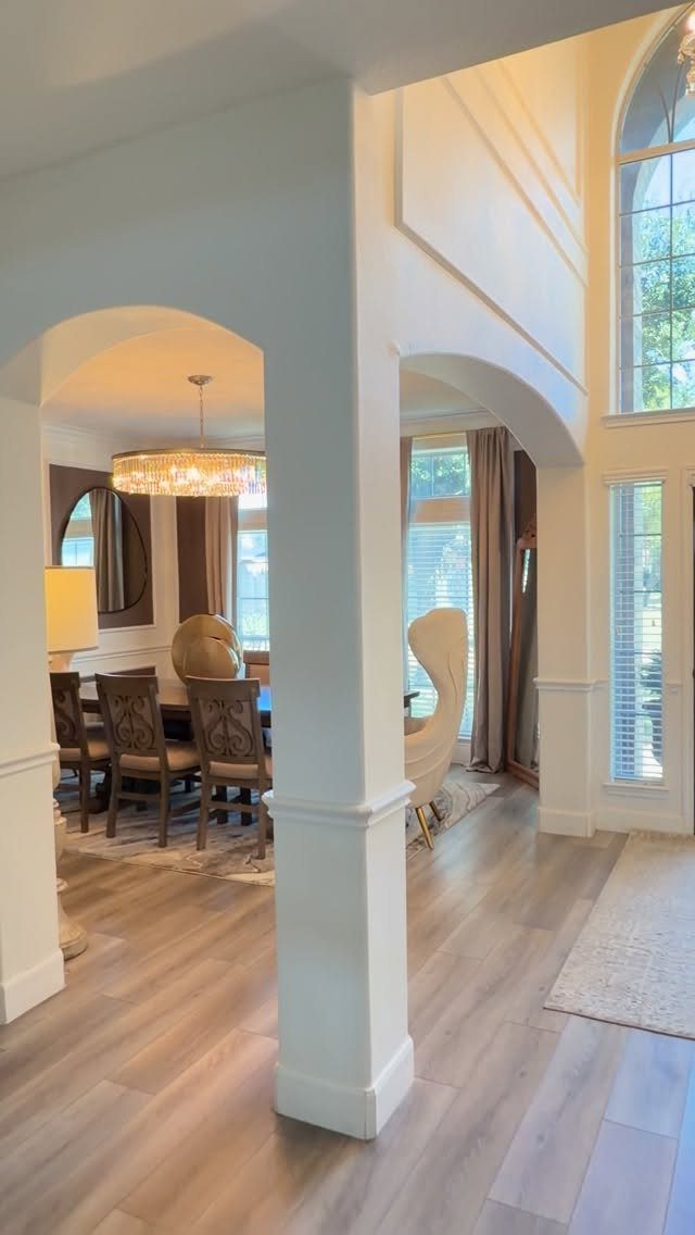 Fabric Chairs Dining Ideas: 32 Styles, Colors, and Frames 18 Beige wingback dining chair and brown upholstered chairs in a bright, arched dining room.