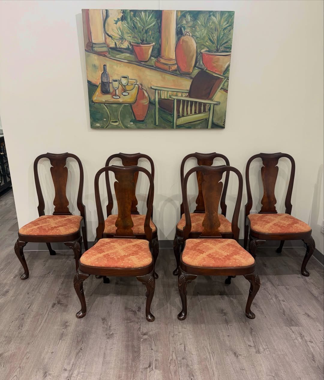 Fabric Chairs Dining Ideas: 32 Styles, Colors, and Frames 25 Four wooden dining chairs with orange fabric seats arranged under a painting.