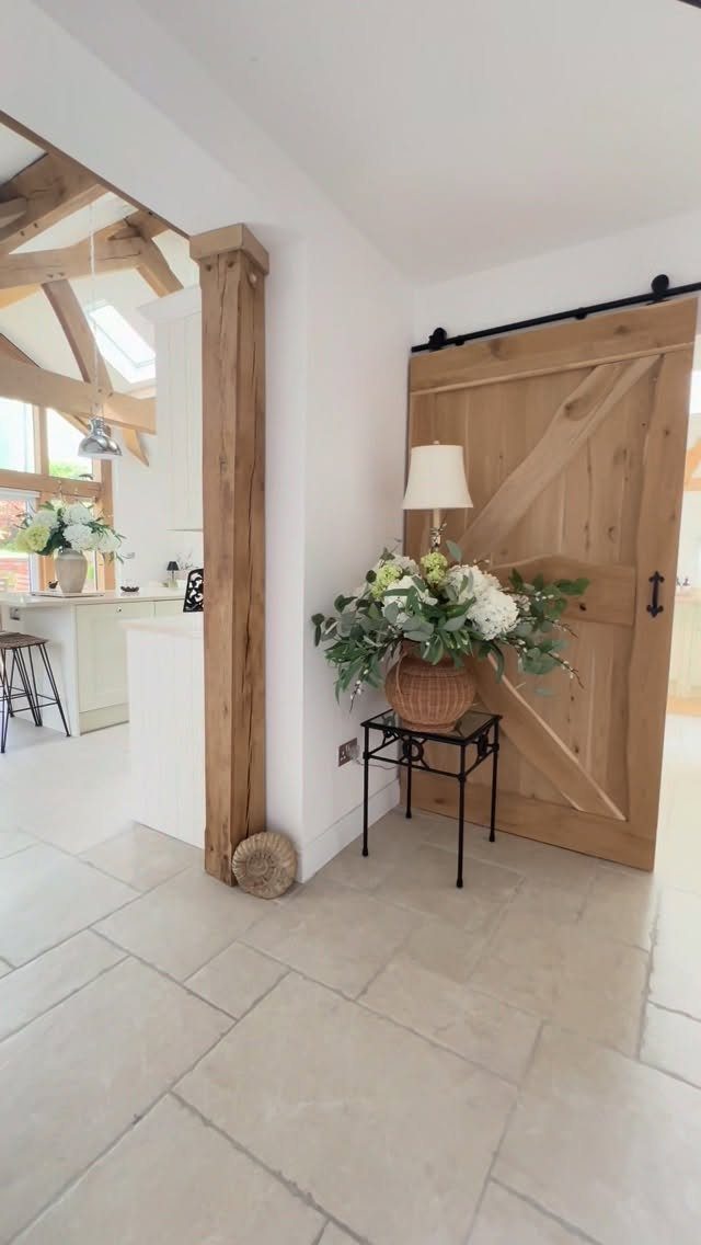 35 Farmhouse Kitchen Remodel Ideas Worth Stealing 20 Natural wood sliding barn door with black hardware in a bright farmhouse interior