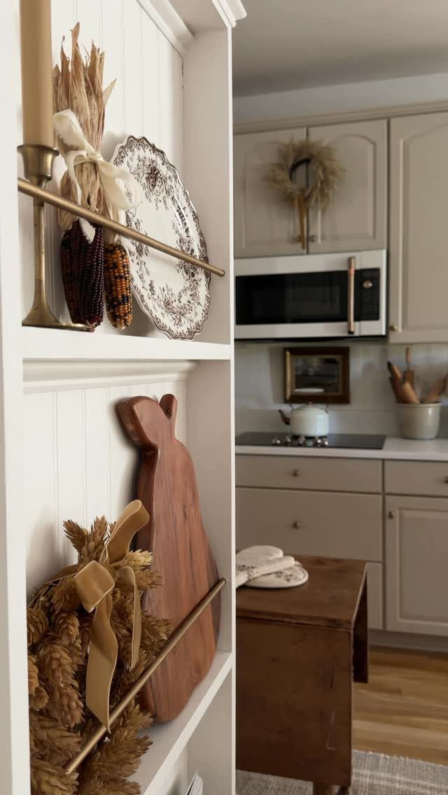35 Farmhouse Kitchen Remodel Ideas Worth Stealing 21 White built-in shelves with beadboard backing holding rustic kitchen decor and wooden boards.