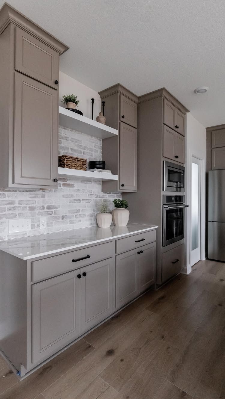 35 Farmhouse Kitchen Remodel Ideas Worth Stealing 24 White brick backsplash in a kitchen with grey cabinets and wooden floors