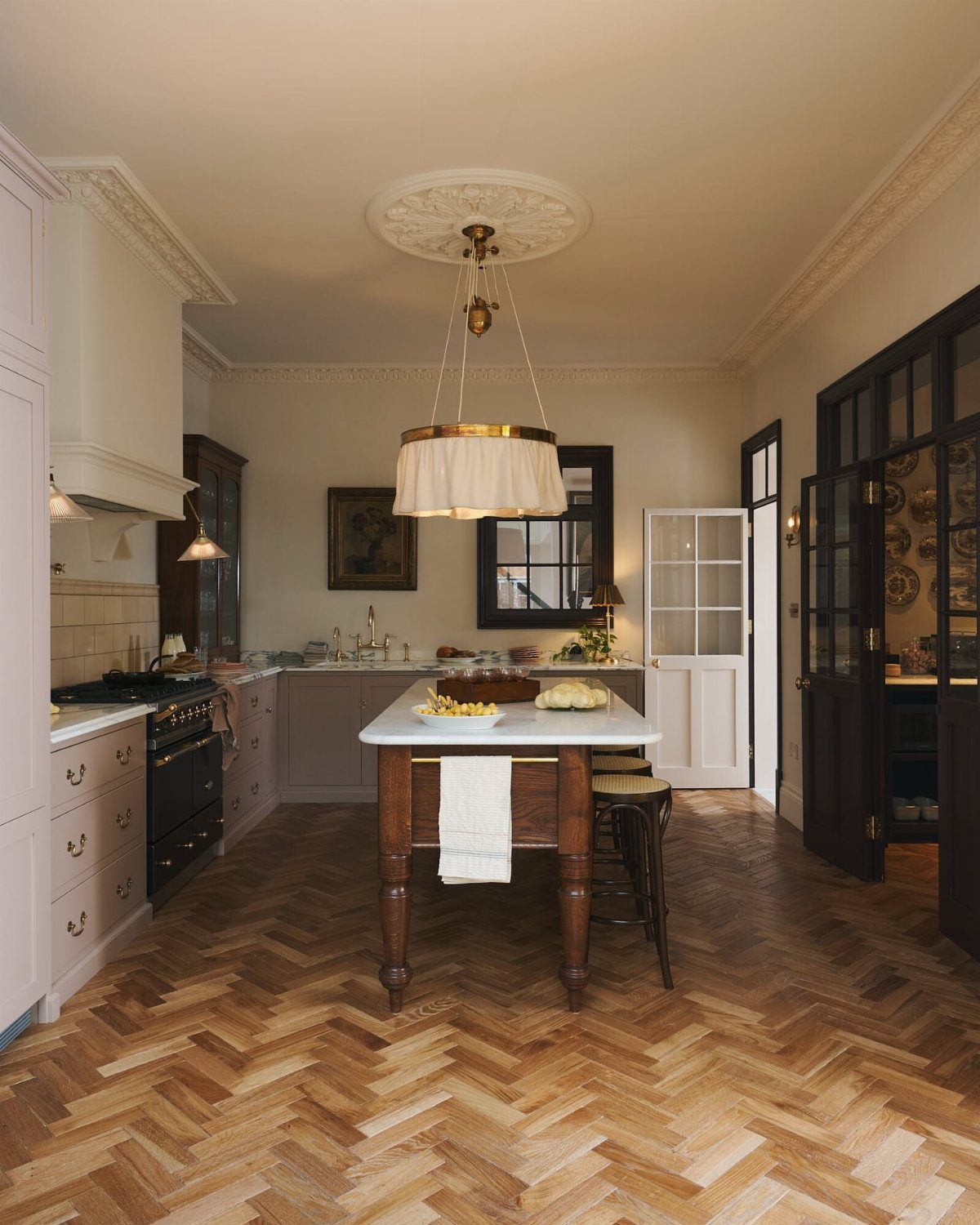 35 Farmhouse Kitchen Remodel Ideas Worth Stealing 13 Kitchen island with white countertop and herringbone wood floors in a farmhouse style.