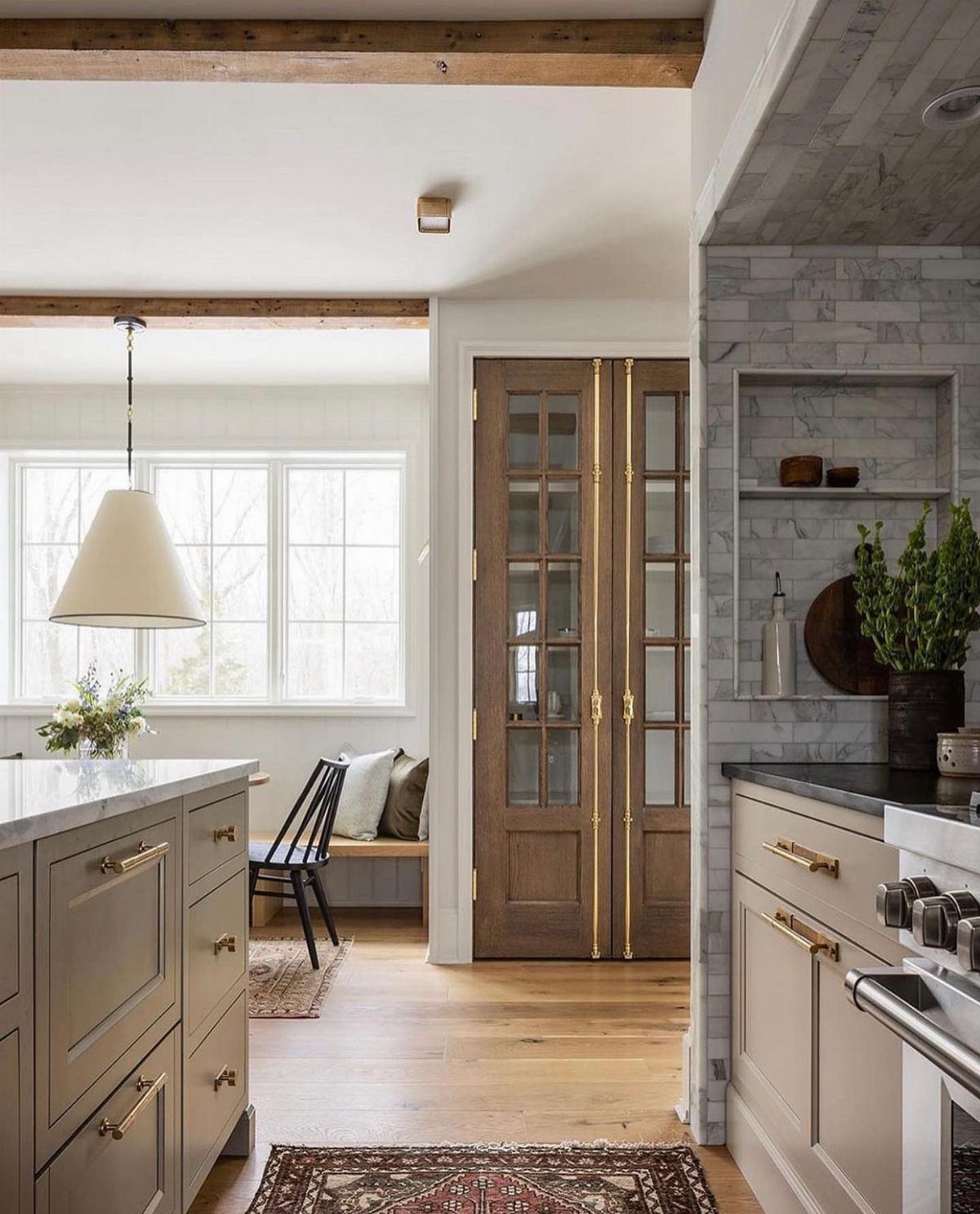 35 Farmhouse Kitchen Remodel Ideas Worth Stealing 34 Grey kitchen cabinets and marble tile backsplash with light wood floors and beams.