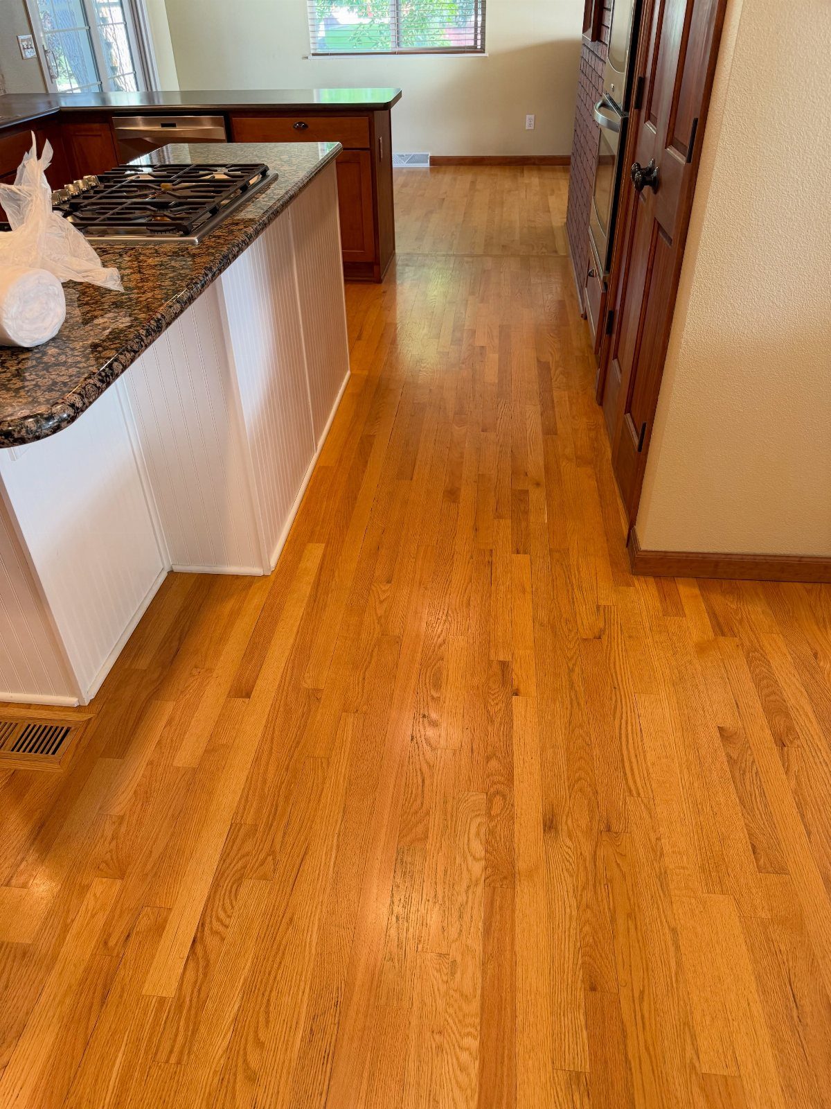35 Farmhouse Kitchen Remodel Ideas Worth Stealing 26 Polished light-brown hardwood flooring in a kitchen with white island cabinets.
