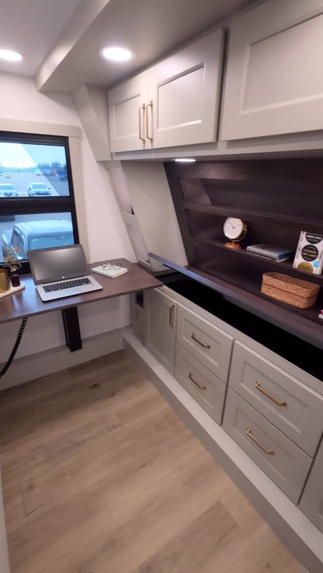 23 Fifth Wheel Remodel Ideas for Storage, Color, and Comfort 15 Renovated fifth wheel interior with grey cabinets, a workspace, and light wood floors.