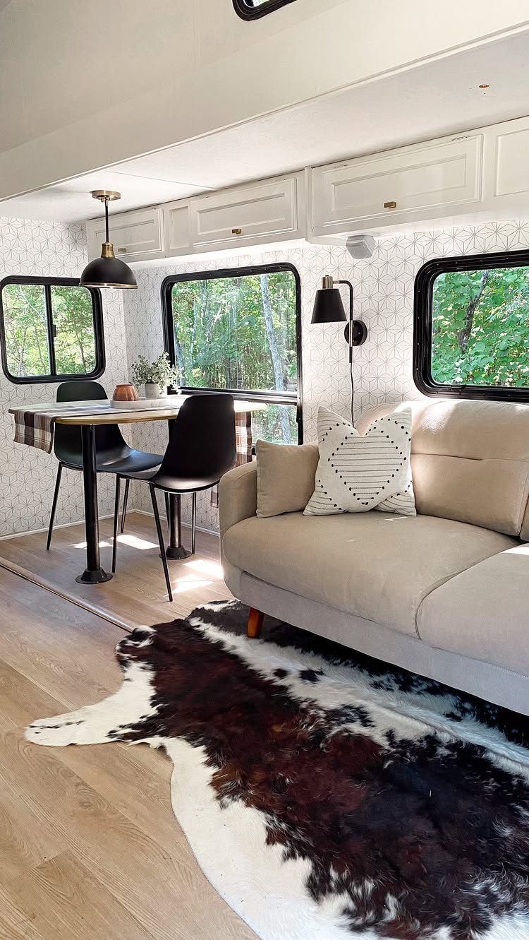 23 Fifth Wheel Remodel Ideas for Storage, Color, and Comfort 23 Renovated fifth wheel interior with beige sofa, cowhide rug, and modern dining area.