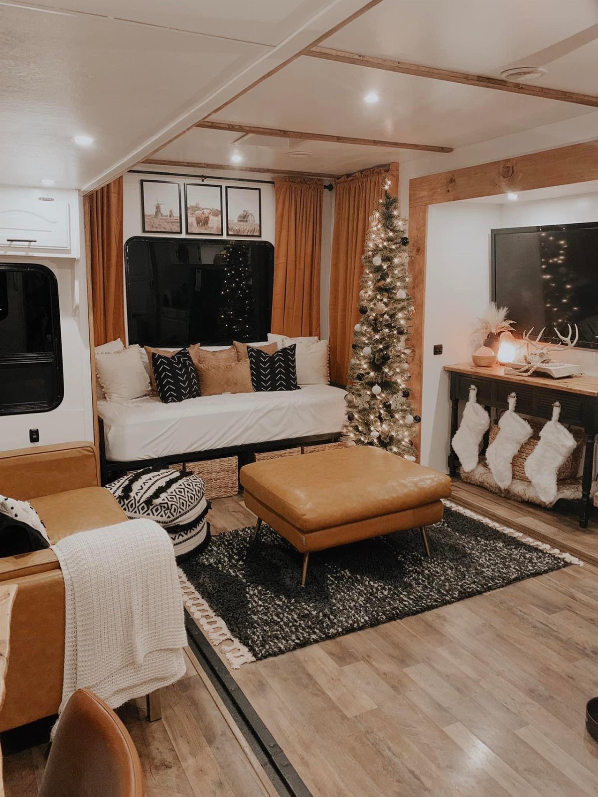 23 Fifth Wheel Remodel Ideas for Storage, Color, and Comfort 5 Three framed travel photos hanging on the wall above a white RV sofa.