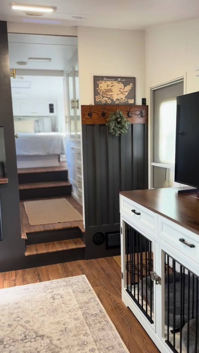 23 Fifth Wheel Remodel Ideas for Storage, Color, and Comfort 22 Remodeled fifth wheel interior with grey walls, wood floors, and white cabinetry.
