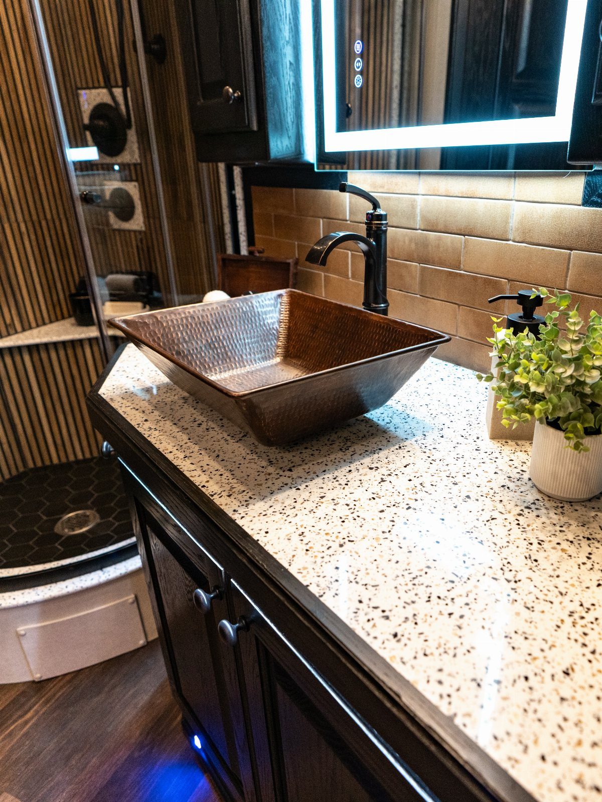 23 Fifth Wheel Remodel Ideas for Storage, Color, and Comfort 21 Copper vessel sink on a speckled white countertop in a remodeled RV bathroom
