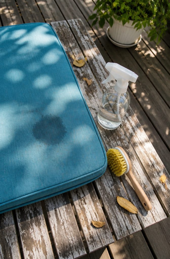An overhead view of a stained cushion and a spray bottle.