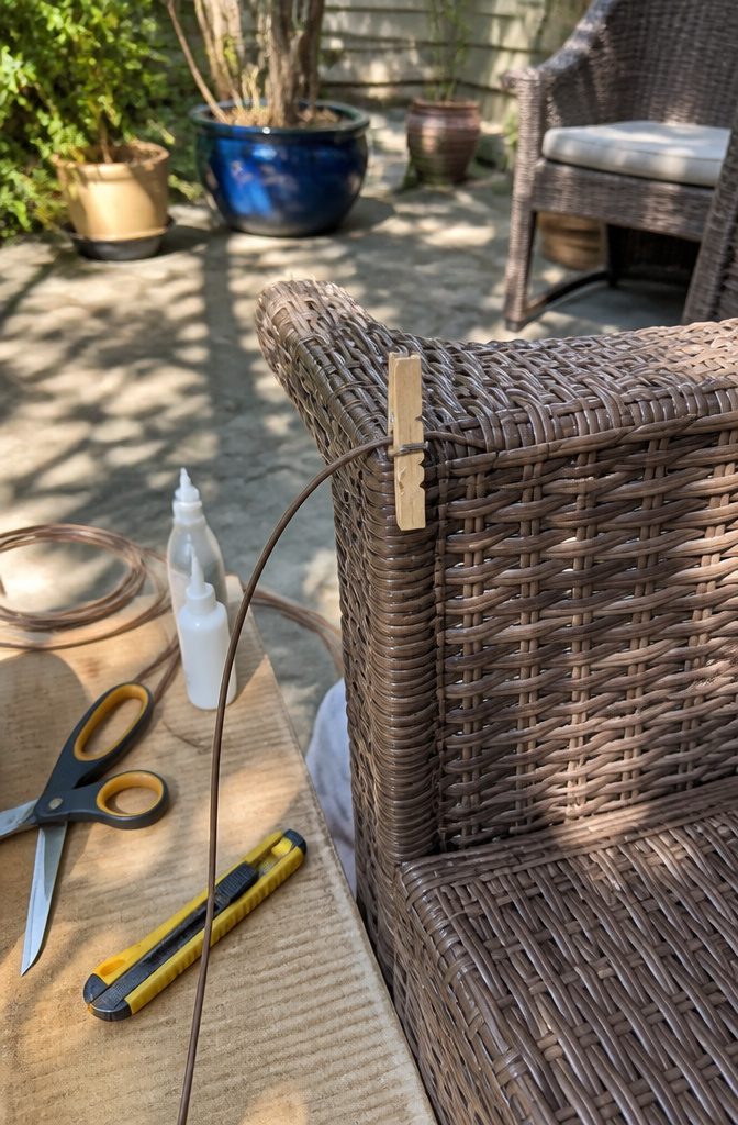 How to Repair Wicker Patio Furniture: A 2026 Guide to Fixing Unraveled Weave 4 Clothespin holding a woven strand on a wicker chair.