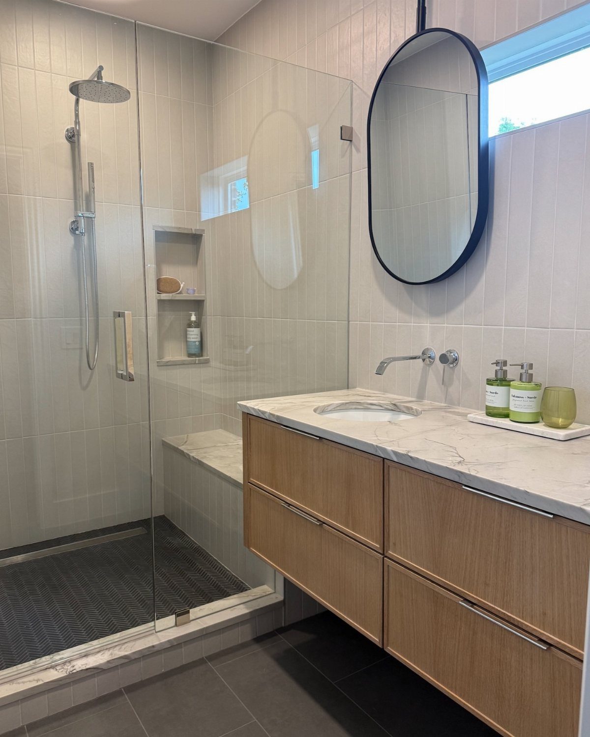 17 Jack and Jill Bathroom Remodel Ideas for Shared Spaces 2 Modern bathroom with floating wooden vanity and glass shower along one wall.